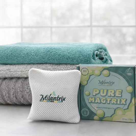 Milantrix laundry sachet with box and folded towels on a light background with freshly washed towels. 